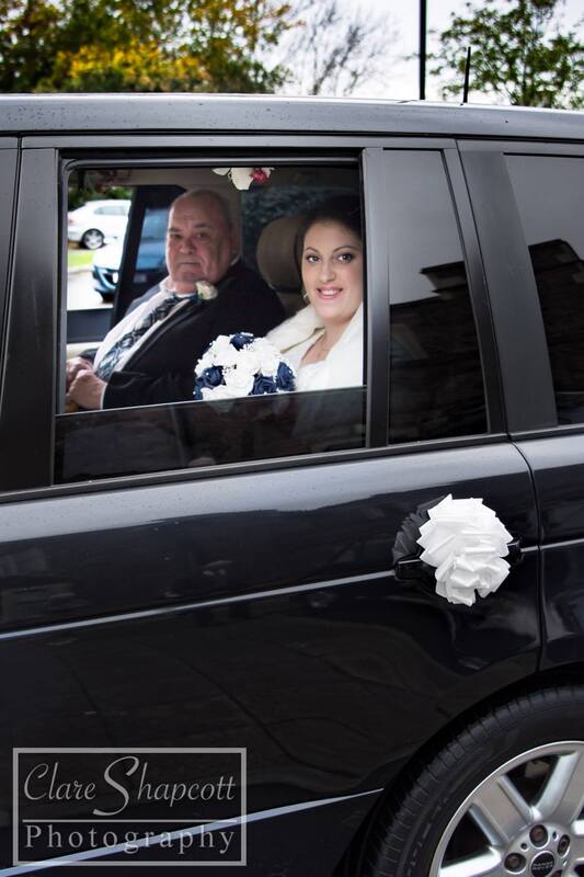 Bride arrives at wedding with father in car carrying bouquet
