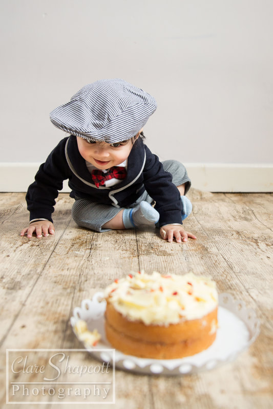 A seven month old boy with his eye on his cake in our Henbury studio, Bristol
