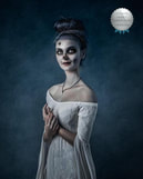 Award winning photograph of woman in white dress, hair in a bun, with skeleton makeup, in front of a blue background.