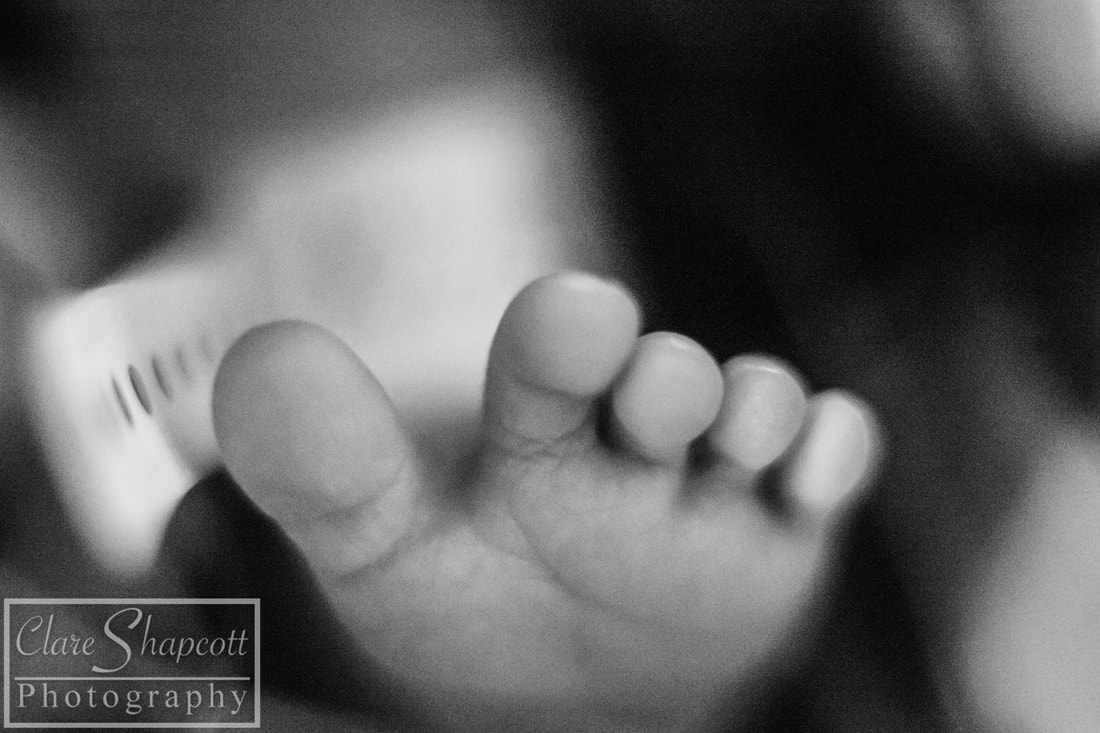 Close up photo of premature baby's foot with tag in black and white