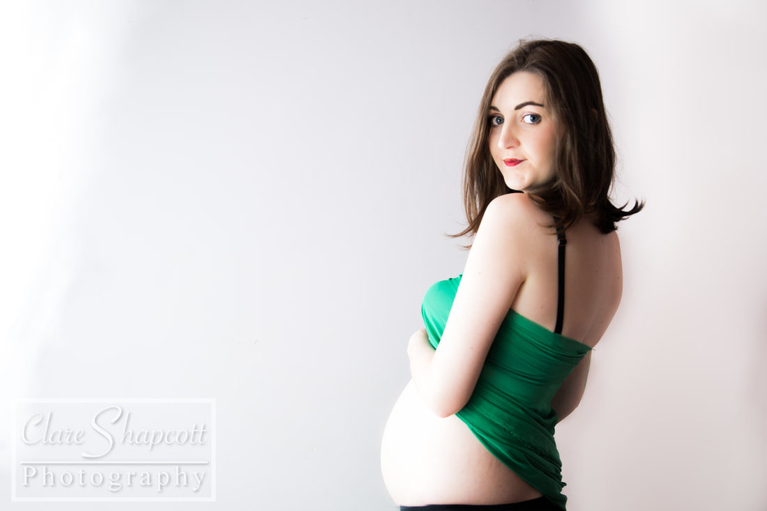 Precious maternity photograph with baby bump against white wall