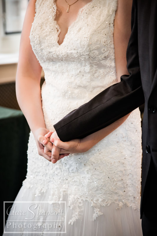 Photograph of husband and wife holding hands at wedding