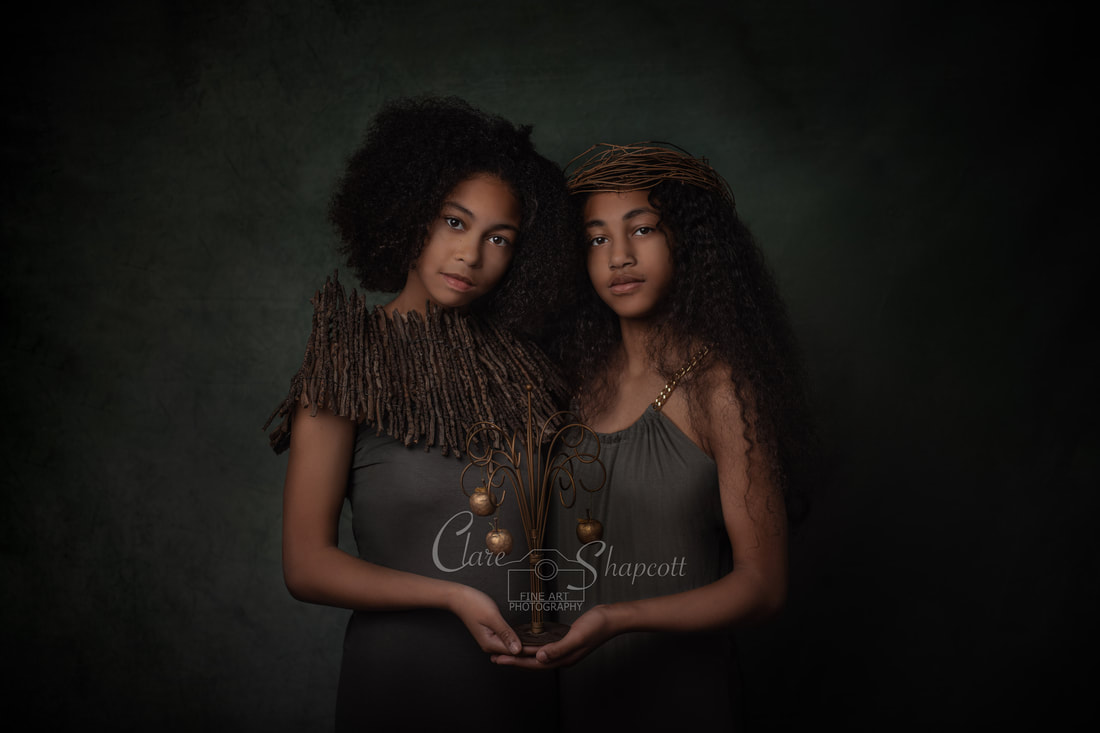 Teenage sisters pose together with fine wooden hair and neck accessories.