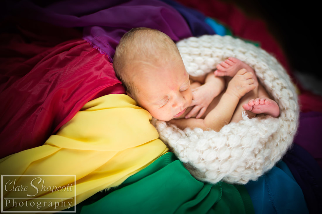 Photo of special rainbow baby in white scarf